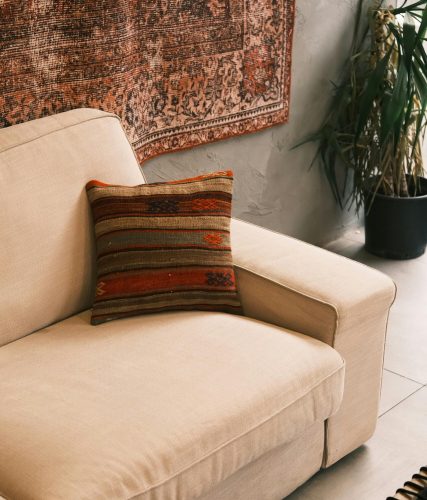 Beige sofa with decorative pillow in a stylish, cozy café interior in Konya, Türkiye.